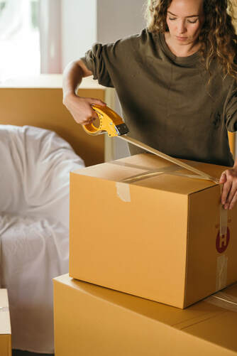 Woman wrapping up boxes | Get paid to move to Italy