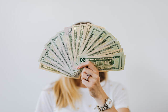 Woman showing a folding fan on money | Average salary in Italy