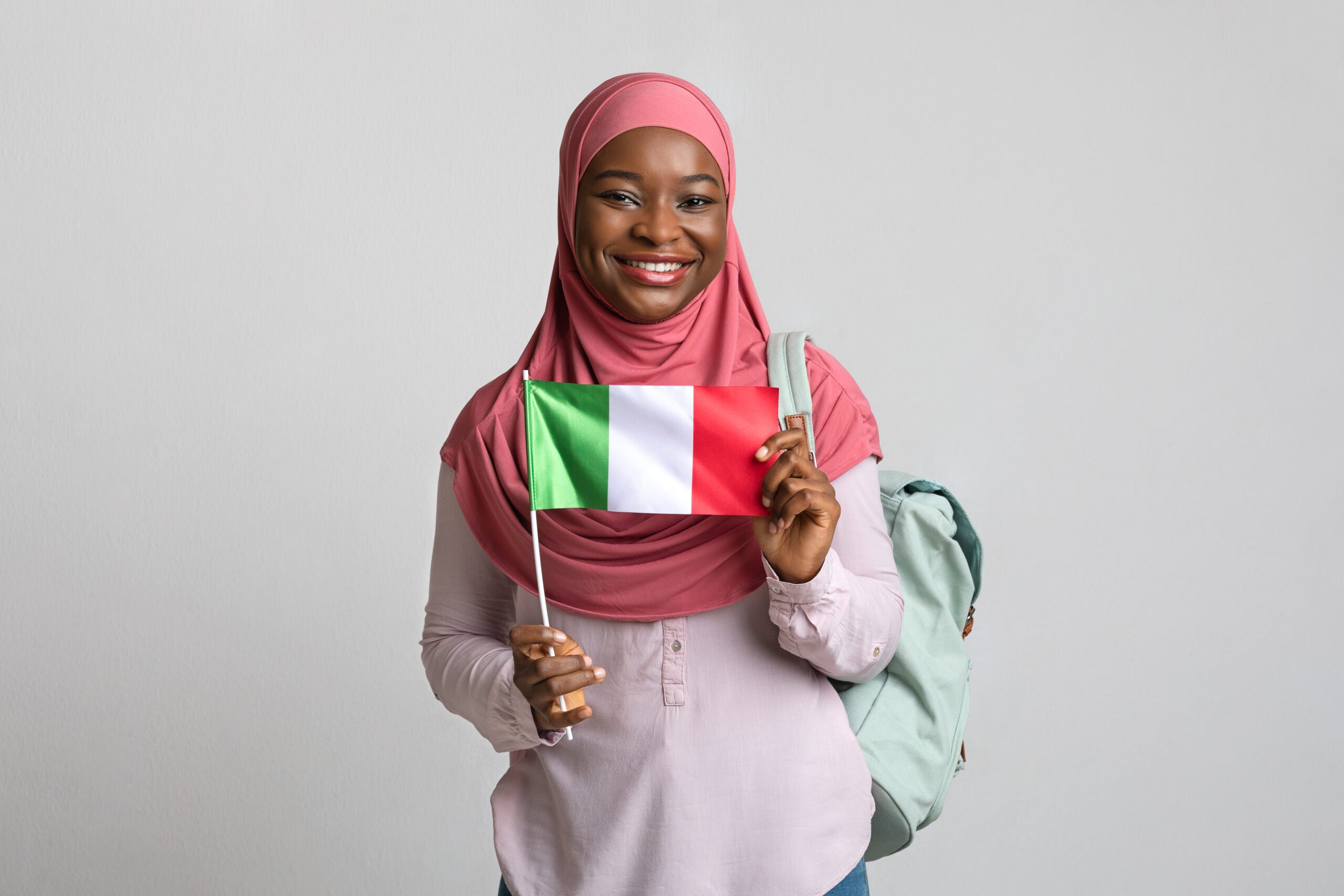 Italian citizenship | Positive black woman in hijab showing flag of Italy
