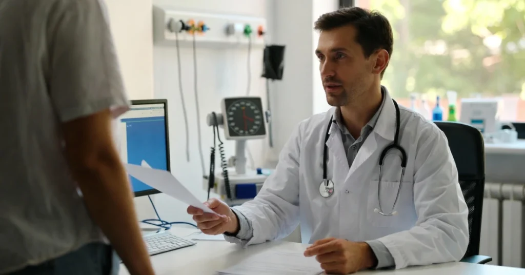 Referring doctor in Italy handing a referral to a patient inside medical office
