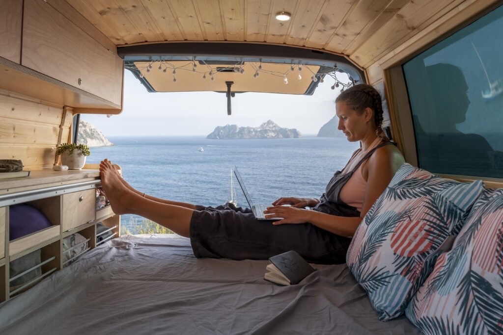 Woman working in a Van relaxed | Van life in Italy